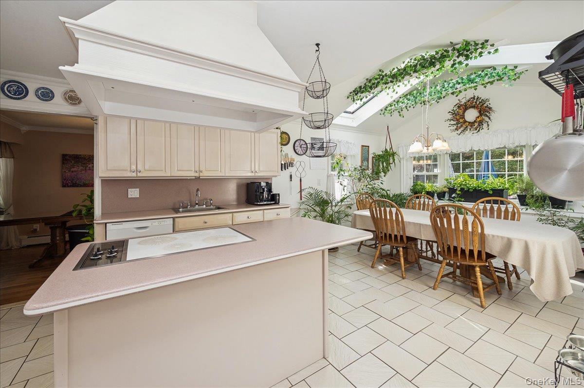 346 Ridgefield Road Hauppauge, NY 11788 - Photo 23 of 45 Kitchen featuring a skylight, a chandelier, light countertops, a center island, and white appliances