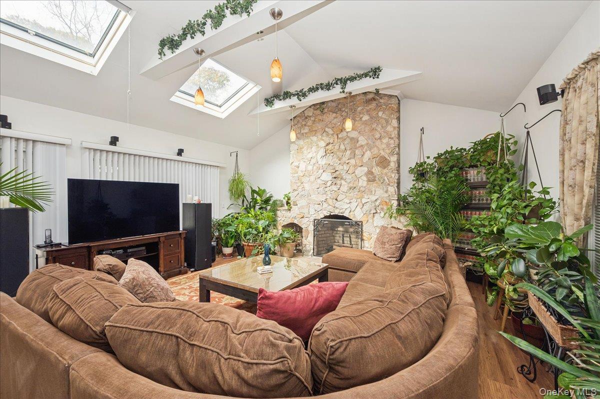 346 Ridgefield Road Hauppauge, NY 11788 - Photo 26 of 45 Living area featuring a skylight, a stone fireplace, wood finished floors, and high vaulted ceiling
