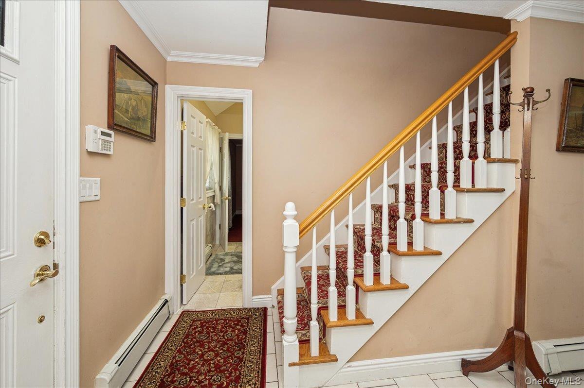 346 Ridgefield Road Hauppauge, NY 11788 - Photo 6 of 45 Stairway featuring crown molding, baseboard heating, and tile patterned floors