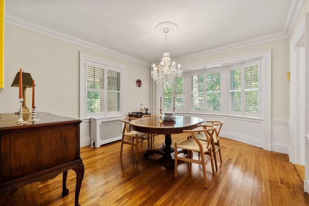 210 Upland Road Newton, MA 02460 - Photo 14 of 41 a view of a dining room with furniture a chandelier and wooden floor