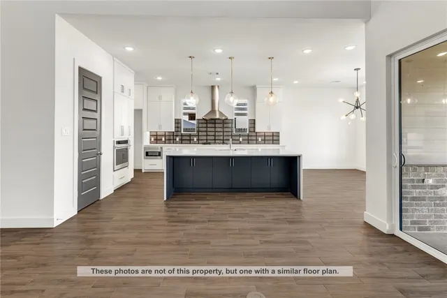 a view of kitchen with kitchen island granite countertop a stove and a refrigerator
