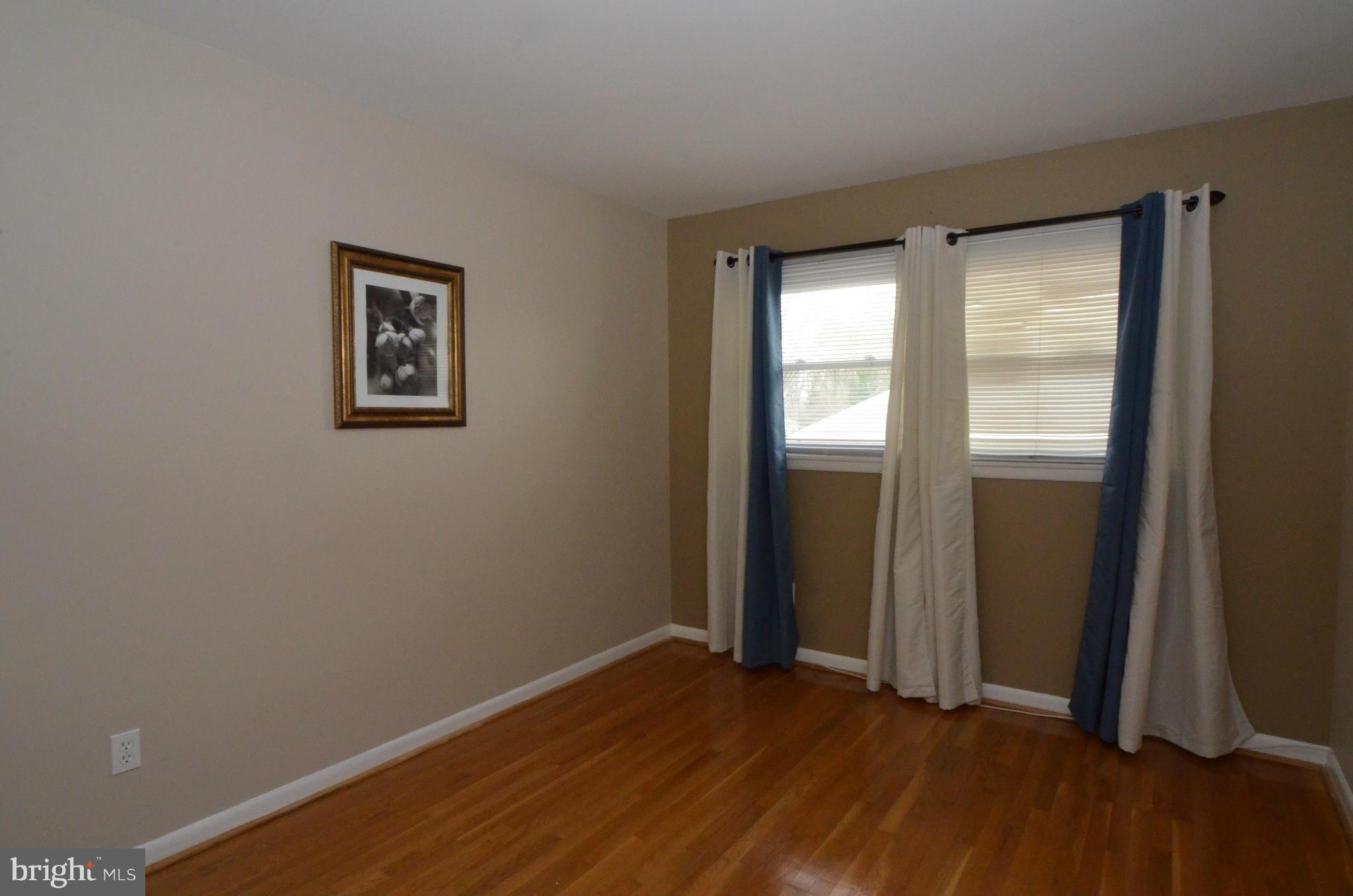 13309 Brackley Road Silver Spring, MD 20904 - Photo 22 of 28 an empty room with wooden floor and windows