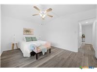 7705 Grovedale Trail Austin, TX 78729 - Photo 14 of 25 a bed room with a bed and a chandelier