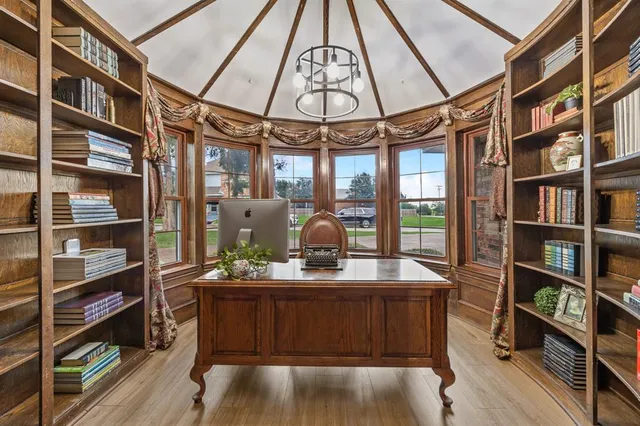 a room with chandelier fan and wooden floor