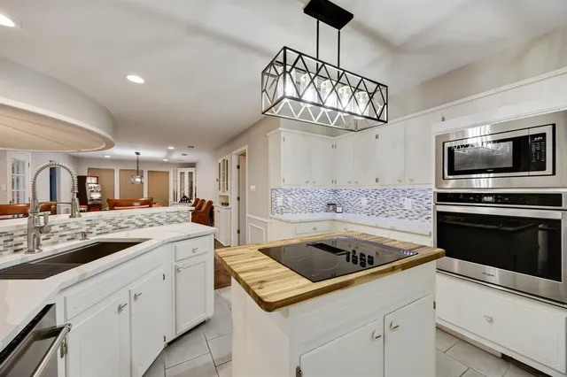 a kitchen with a sink a stove and cabinets
