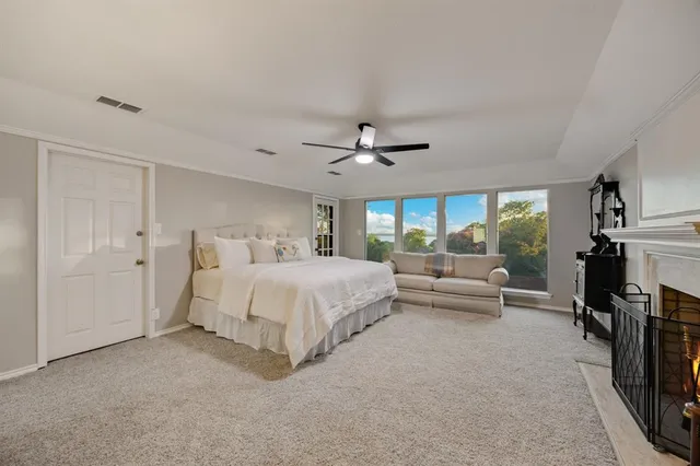 a spacious bedroom with a bed and a ceiling fan