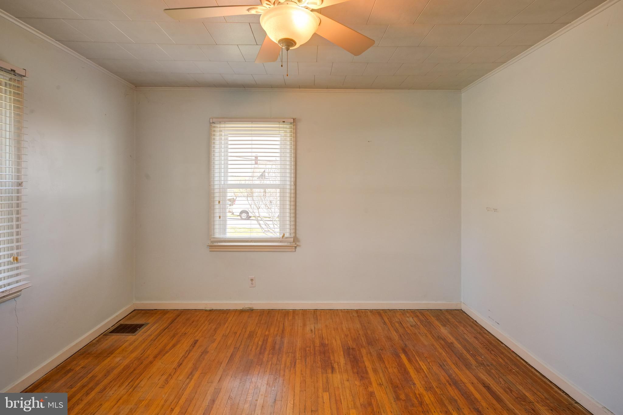 5630 Oakland Road Baltimore, MD 21227 - Photo 24 of 31 an empty room with wooden floor and windows