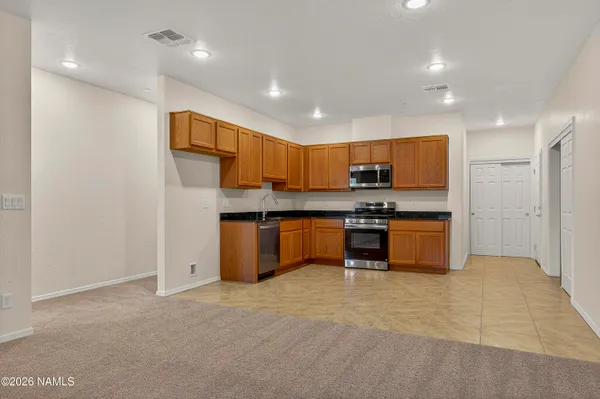 a kitchen with stainless steel appliances granite countertop a stove top oven a sink dishwasher and a microwave oven on the blue kitchen countertops
