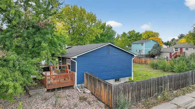 a view of a yard in front of a house with wooden fence