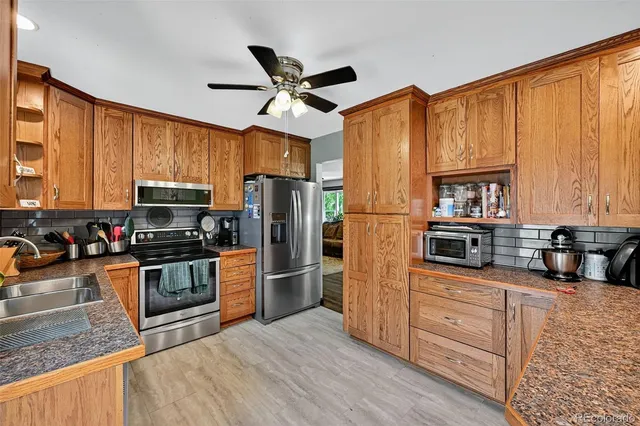 a kitchen with stainless steel appliances granite countertop a refrigerator stove microwave and sink