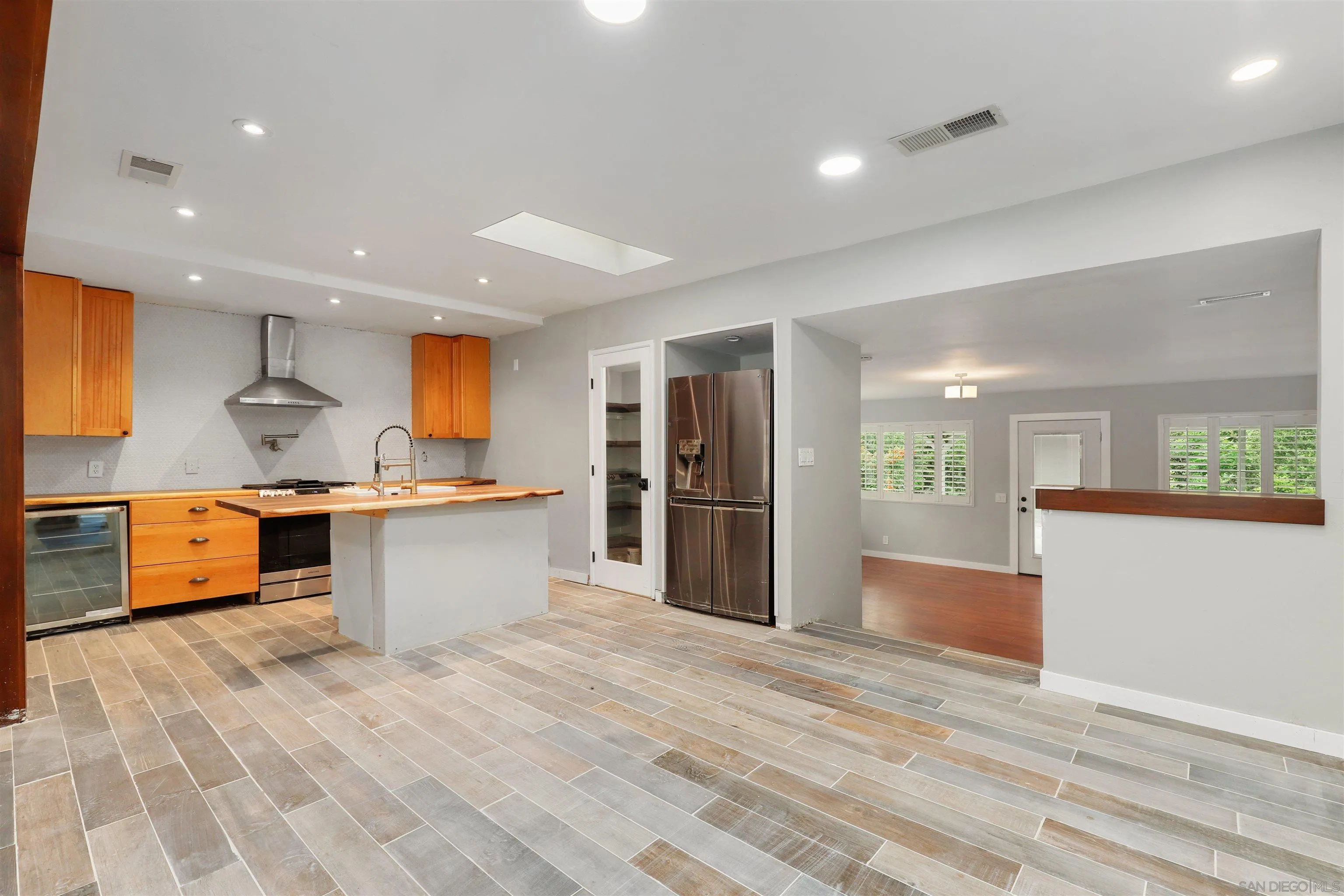 12256 Old Stone Road Poway, CA 92064 - Photo 11 of 31 a large kitchen with stainless steel appliances kitchen island a large counter top and a wooden floors
