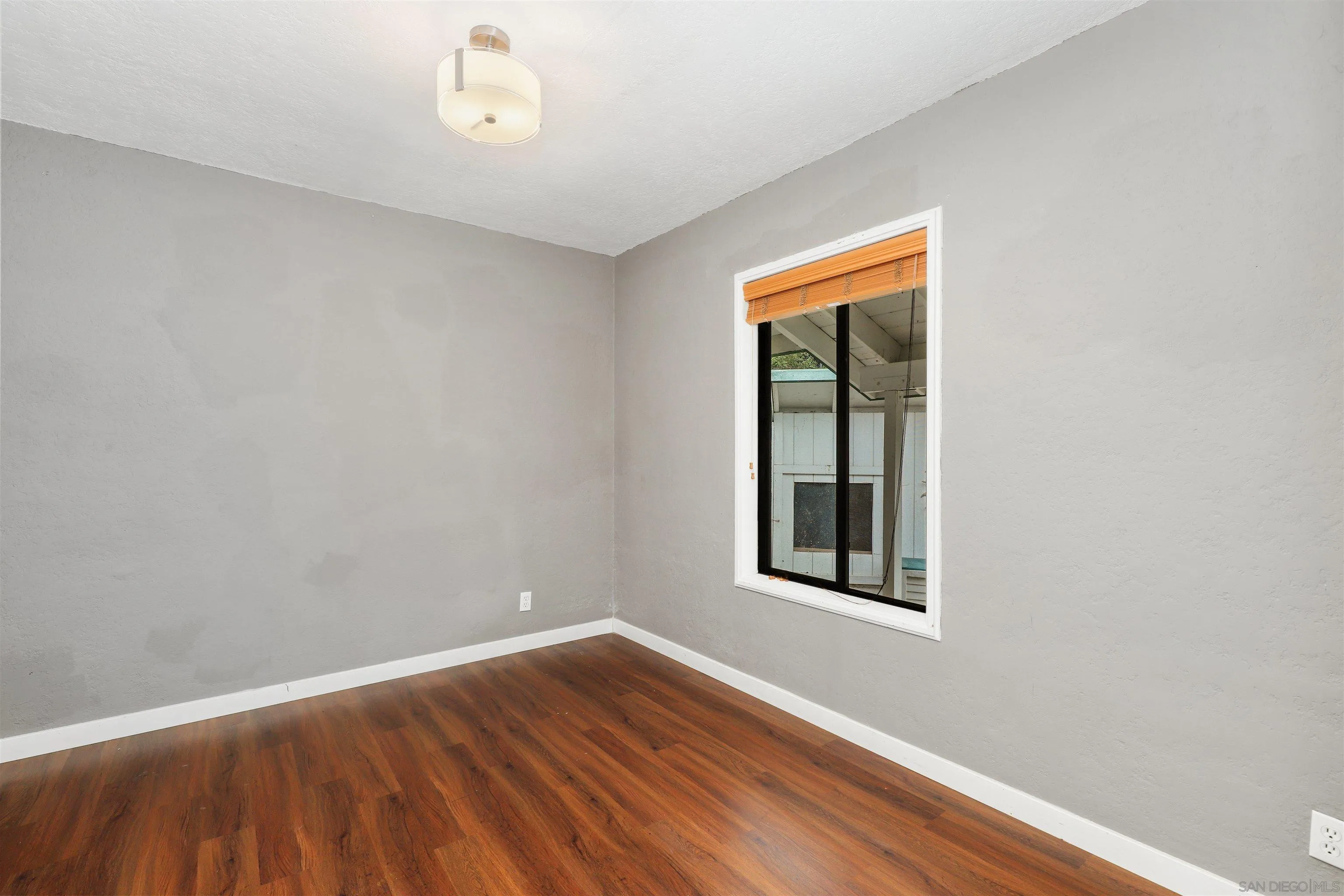 12256 Old Stone Road Poway, CA 92064 - Photo 17 of 31 an empty room with wooden floor and windows