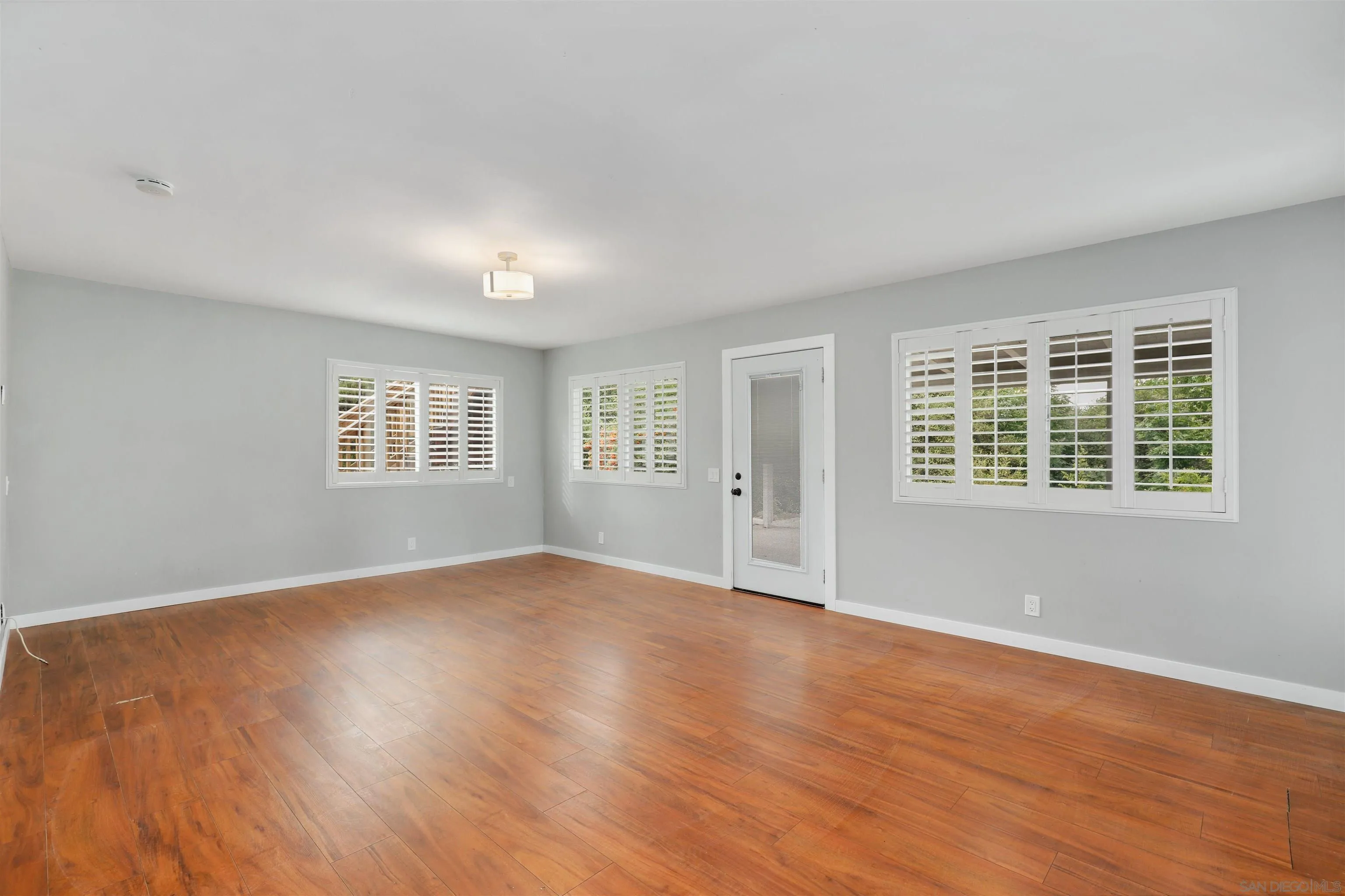 12256 Old Stone Road Poway, CA 92064 - Photo 7 of 31 an empty room with wooden floor and windows
