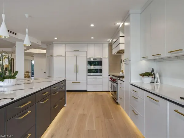 a kitchen with kitchen island granite countertop a sink refrigerator and cabinets