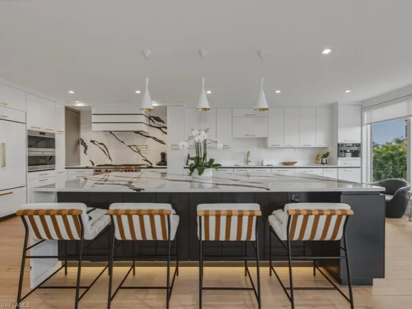 a kitchen with a dining table chairs and white cabinets