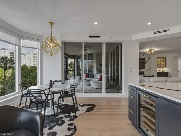 a dining hall with couches a flat tv screen and a dining table with garden view