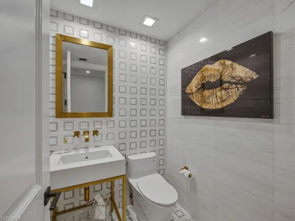 a bathroom with a toilet sink and mirror