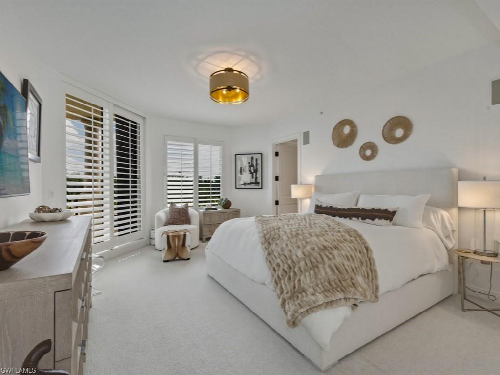 8787 Bay Colony Drive, Unit 306 Naples, FL 34108 - Photo 20 of 40 a bedroom with a bed and a table