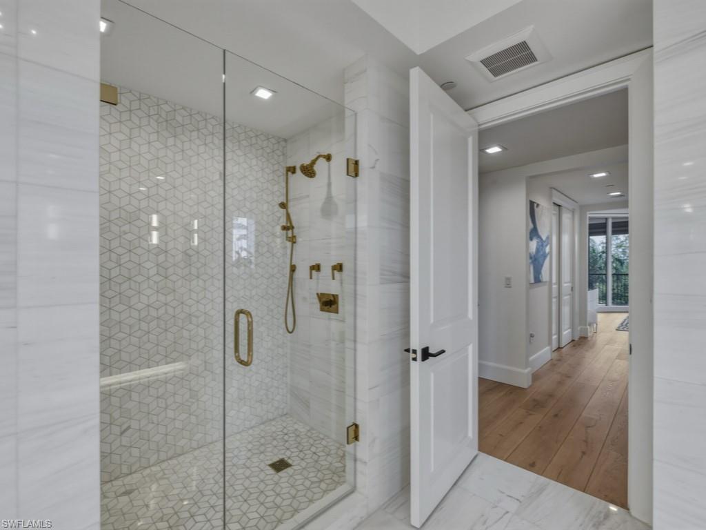 8787 Bay Colony Drive, Unit 306 Naples, FL 34108 - Photo 22 of 40 a bathroom with a glass shower door