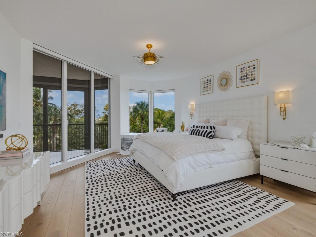 8787 Bay Colony Drive, Unit 306 Naples, FL 34108 - Photo 23 of 40 a bedroom with a bed and a large window