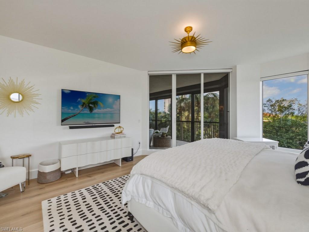 8787 Bay Colony Drive, Unit 306 Naples, FL 34108 - Photo 24 of 40 a bedroom with a bed and a large window