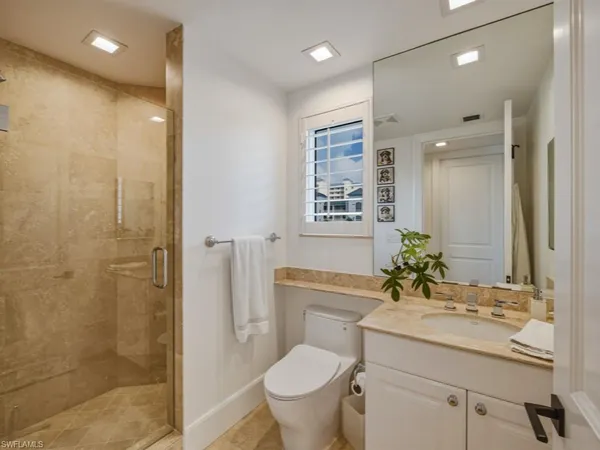 a bathroom with a granite countertop sink toilet and shower