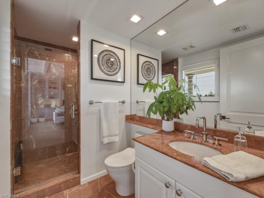 8787 Bay Colony Drive, Unit 306 Naples, FL 34108 - Photo 30 of 40 a bathroom with a granite countertop sink a toilet and shower