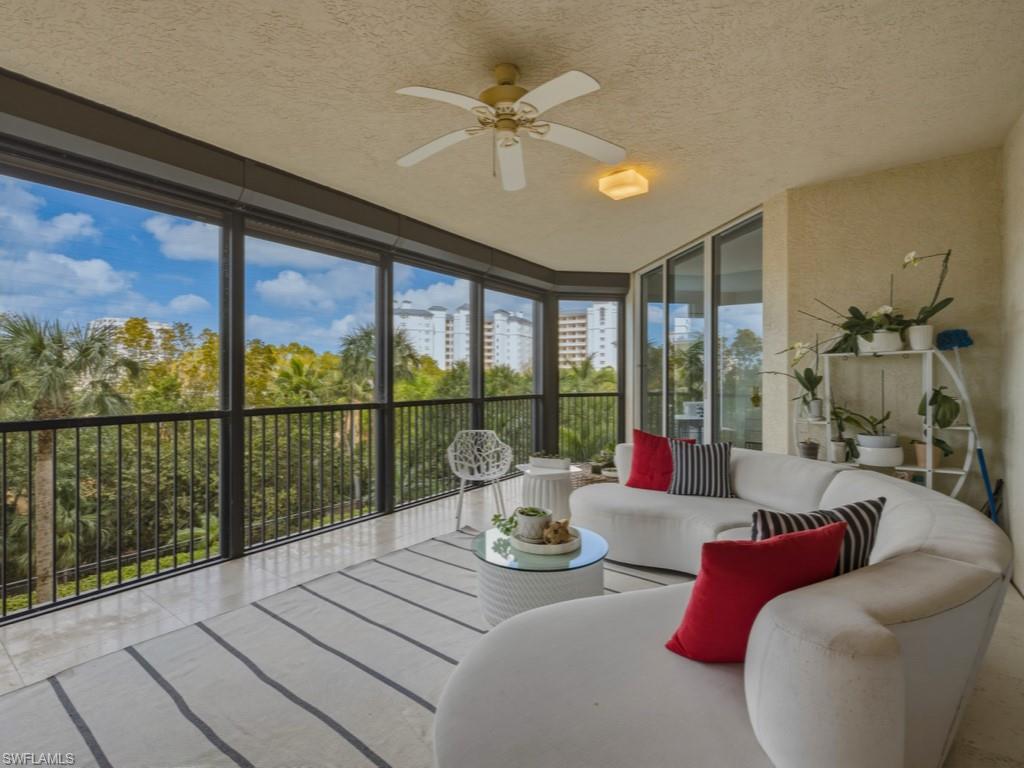 8787 Bay Colony Drive, Unit 306 Naples, FL 34108 - Photo 34 of 40 a living room with furniture and floor to ceiling windows