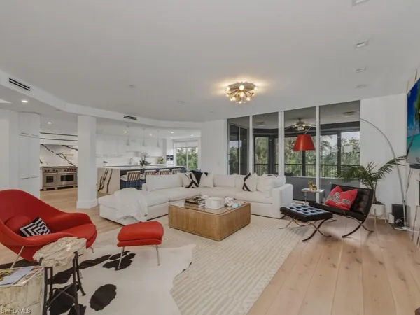 a living room with furniture fireplace and large windows