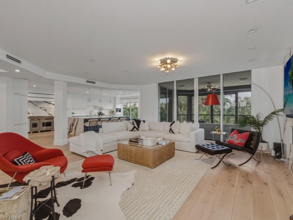 8787 Bay Colony Drive, Unit 306 Naples, FL 34108 - Photo 5 of 40 a living room with furniture fireplace and large windows
