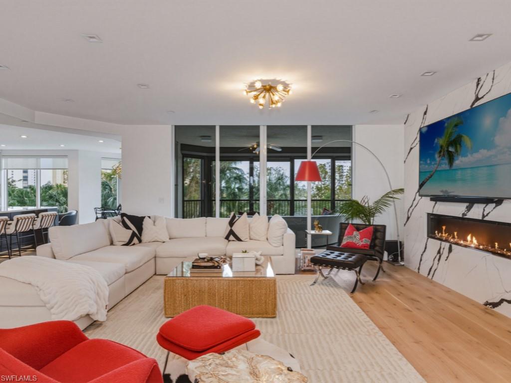 8787 Bay Colony Drive, Unit 306 Naples, FL 34108 - Photo 6 of 40 a living room with furniture a fireplace and a flat screen tv