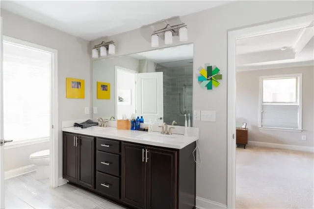 a en suite bathroom with a granite countertop sink and a mirror