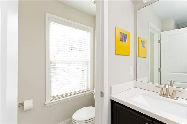a bathroom with a granite countertop sink toilet and mirror