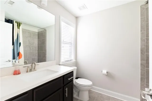 a bathroom with a sink vanity toilet and a mirror