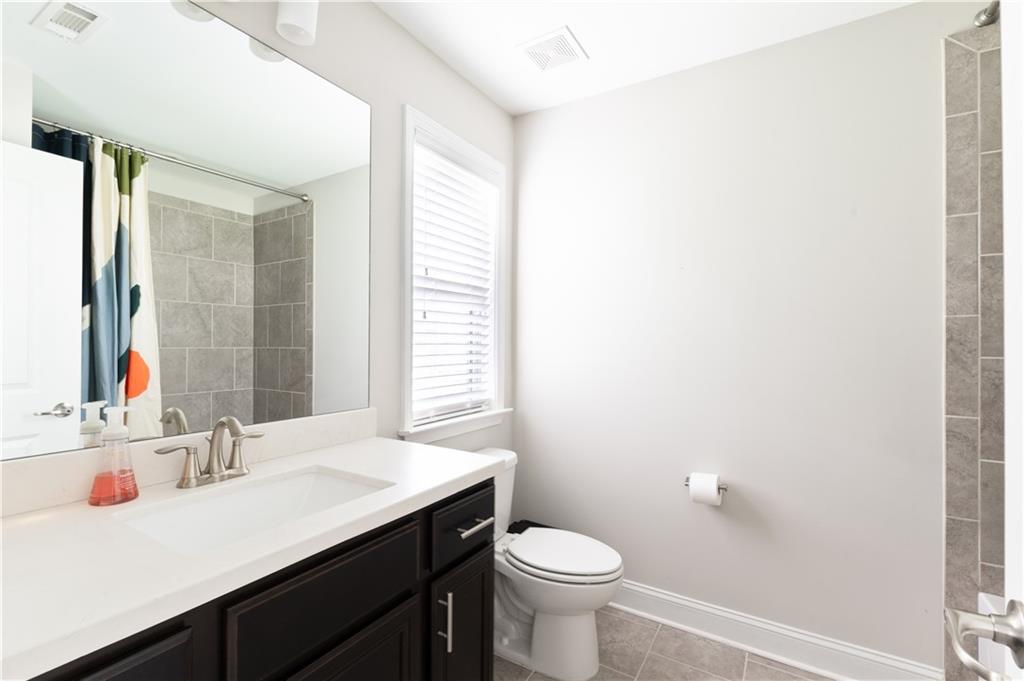 1940 Townsend Court, Unit 15 Atlanta, GA 30329 - Photo 21 of 36 a bathroom with a sink vanity toilet and a mirror