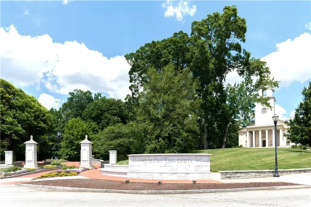 a view of a yard in front of a house with large trees