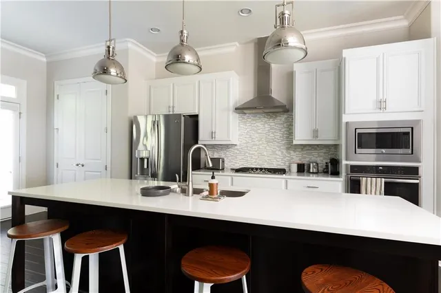 a kitchen with stainless steel appliances a dining table chairs sink and refrigerator