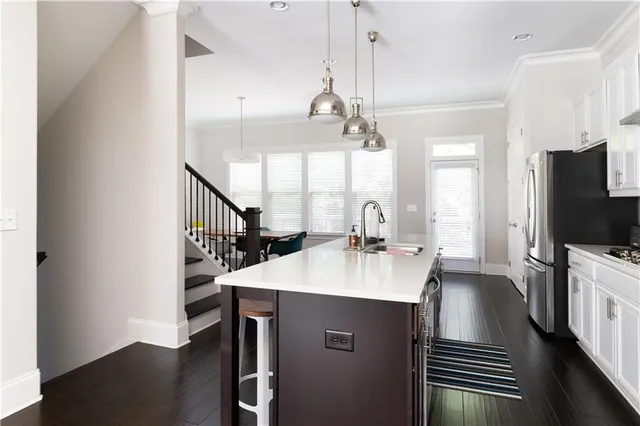 a kitchen with kitchen island a sink appliances and a counter top space