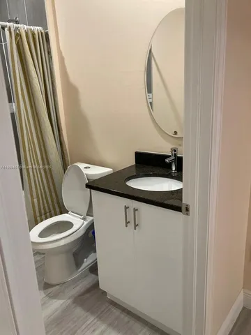 a bathroom with a sink a toilet and a mirror