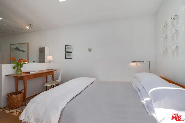 a bedroom with a bed and a desk