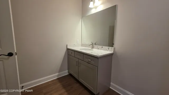 a utility room with a sink vanity and a mirror