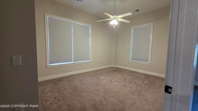 en empty room with windows and fan