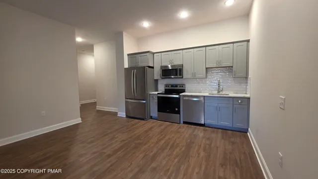 a kitchen with stainless steel appliances a sink stove and refrigerator