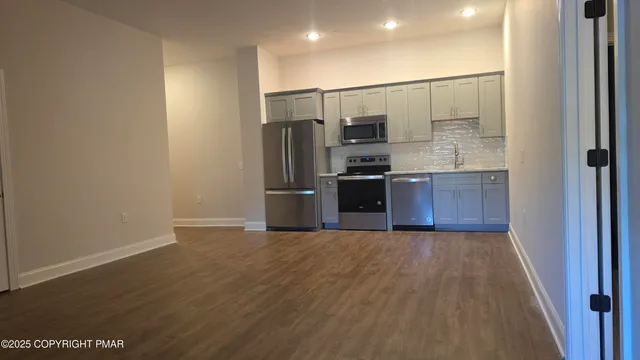 a view of a kitchen with a sink and stainless steel appliances