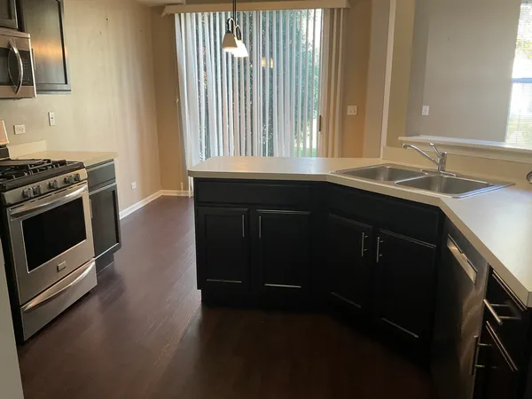 a kitchen with granite countertop a stove a sink and a window