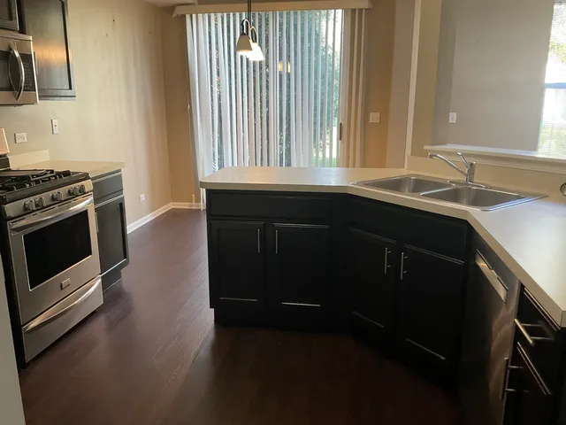a kitchen with granite countertop a stove a sink and a window