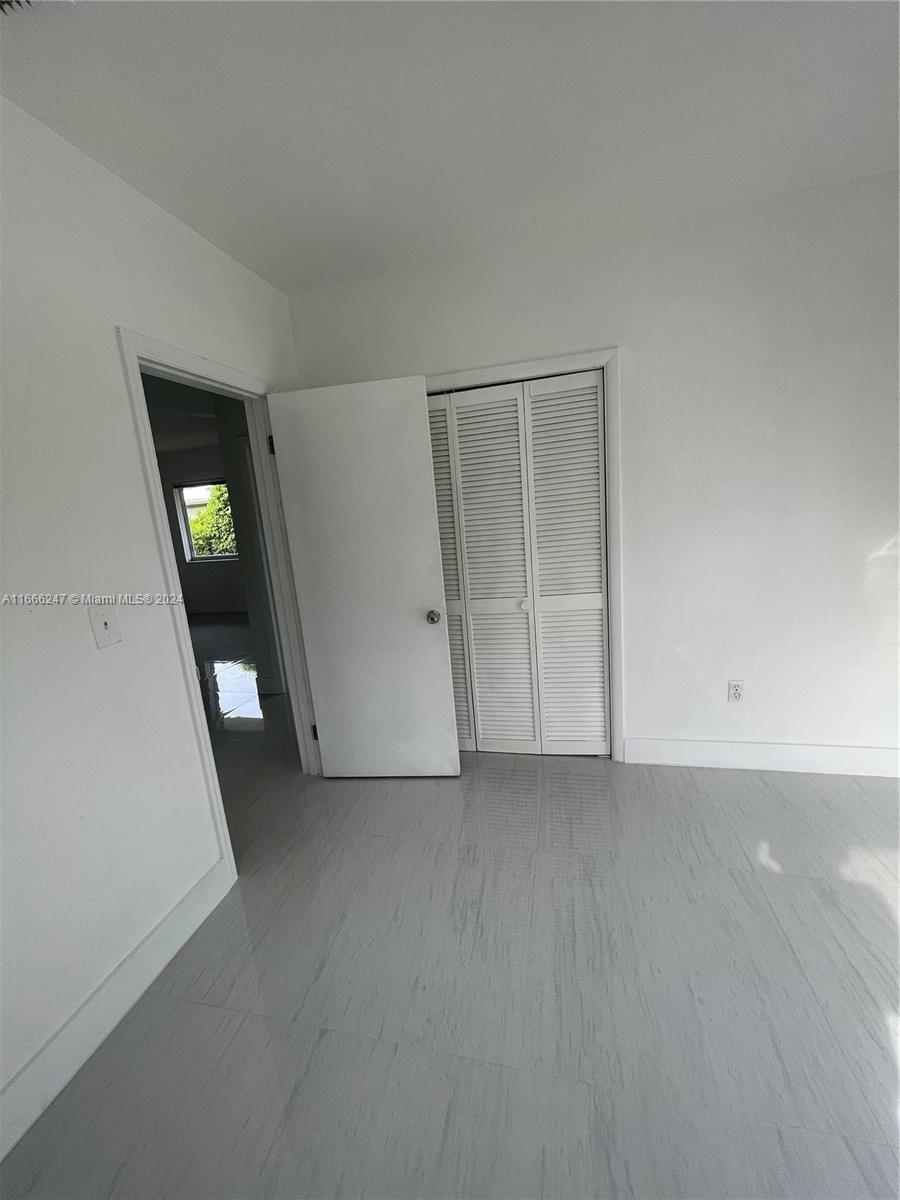 3112 Southwest 16th Street, Unit 3110 Miami, FL 33145 - Photo 19 of 19 an empty room with closet and mirror