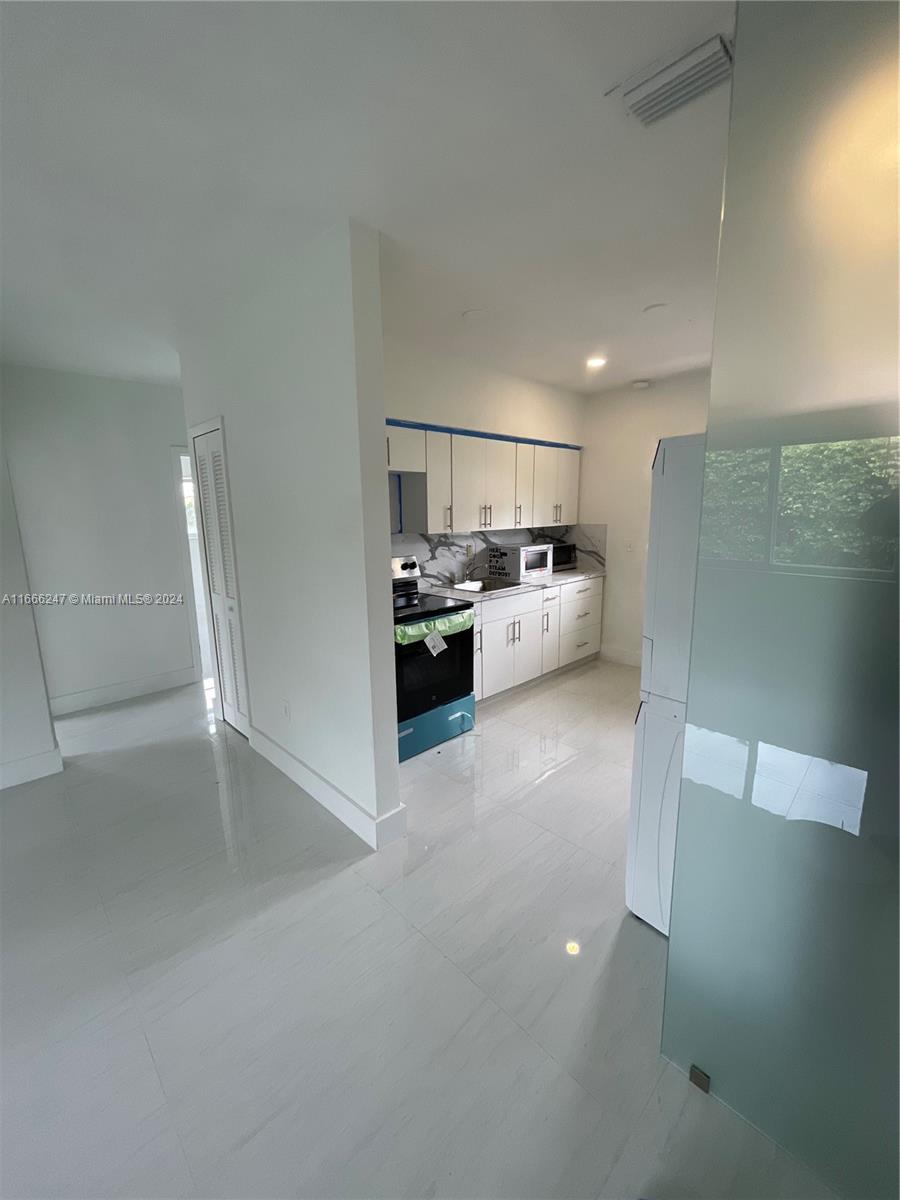 3112 Southwest 16th Street, Unit 3110 Miami, FL 33145 - Photo 6 of 19 a kitchen with stainless steel appliances a refrigerator and a stove top oven