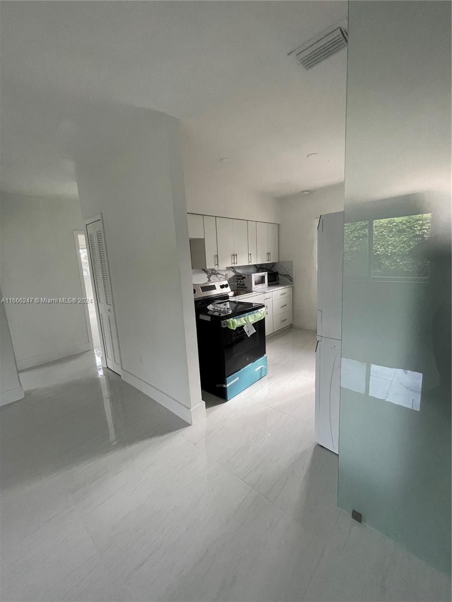 3112 Southwest 16th Street, Unit 3110 Miami, FL 33145 - Photo 7 of 19 a kitchen with granite countertop a refrigerator and a stove