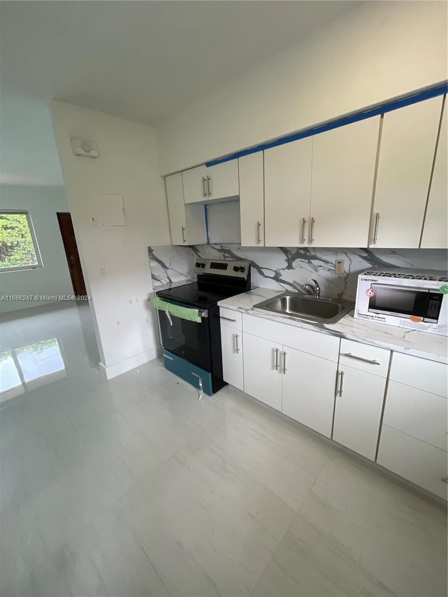 3112 Southwest 16th Street, Unit 3110 Miami, FL 33145 - Photo 9 of 19 a kitchen with stainless steel appliances granite countertop a sink and a stove